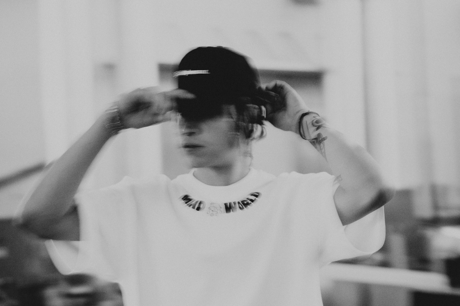 a woman in a white shirt is holding her hair